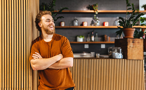 Happy business man standing in front of a cafe in a coworking ofice