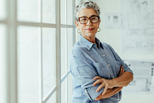 Empowered female designer standing in her office and looking at the camera