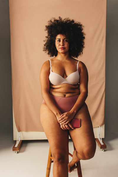 Beautiful woman with an Afro hairstyle wearing underwear in a studio