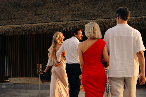 Group of friends walking to luxury resort restaurant for fine dining