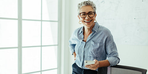 Senior design professional looking at the camera with a smile in her office