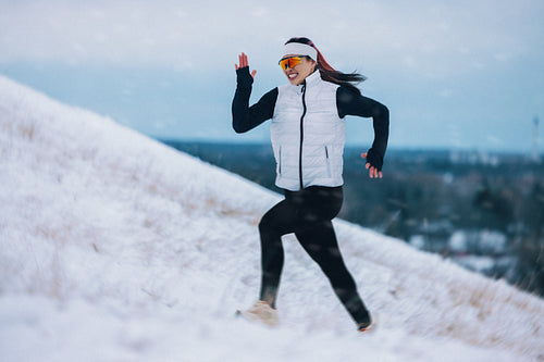 Challenge pushes the woman uphill during winter running on snowy terrain