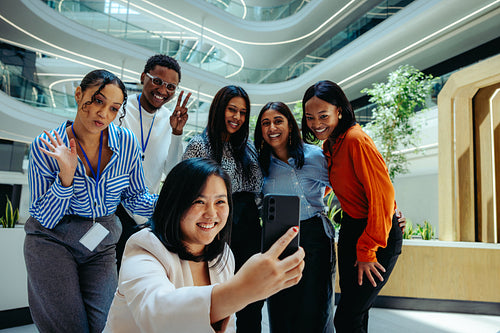 Corporate team taking a cheerful selfie in modern office