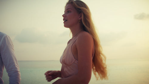 Romantic couple enjoying a beautiful sunset on a luxurious tropical beach during their vacation