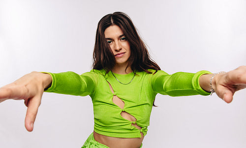 Confident female model reaching toward camera in studio