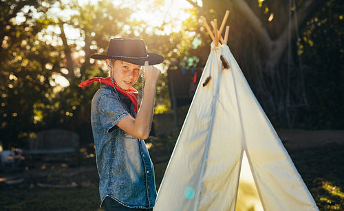 Little boy posing in cowboy hat in backyard