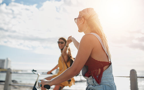 Young women enjoying riding bicycles on a summer day