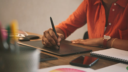 Black graphic designer drawing on a graphics tablet