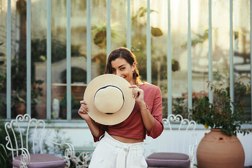 Smiling young woman holding a summer hat