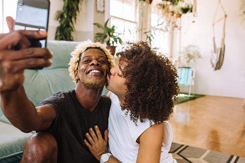 Beautiful gay couple taking a selfie at home