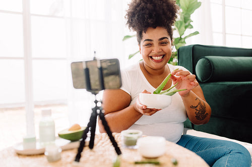 Woman showing aloe vera leaves on beauty care vlog