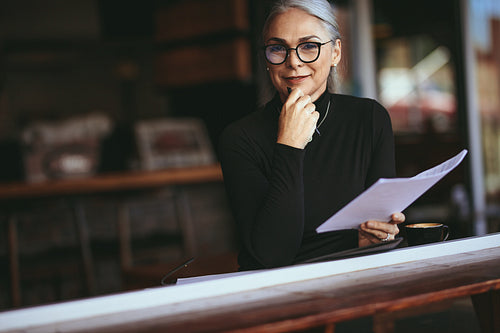Senior woman doing her work sitting at a coffee shop