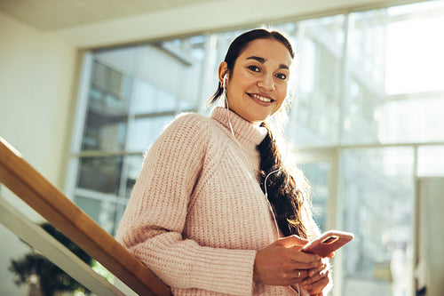 Young woman with cell phone in college campus
