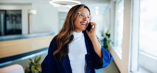 Smiling woman on the phone in office