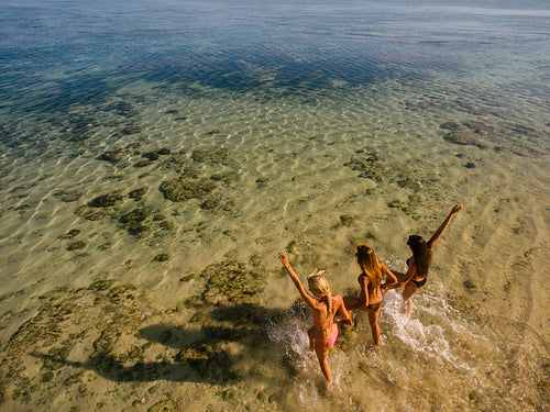 Young women running into the sea