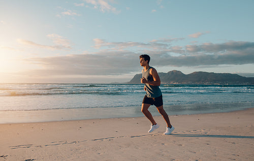 Fit young man jogging on the beach