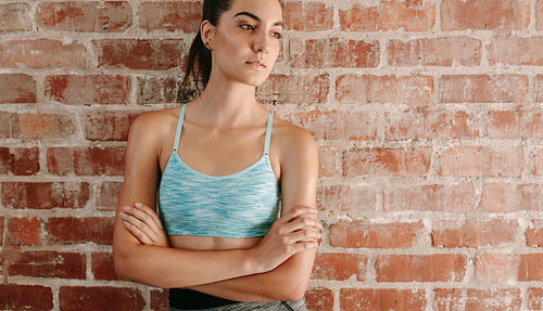 Fit young woman against brick wall 