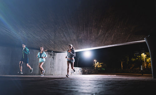 Group of runners training in the city at night