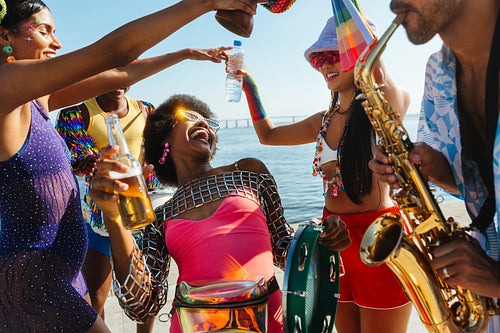 Friends celebrate at beach carnival with music