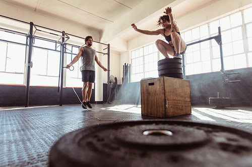 Athletic couple exercising hard at the gym