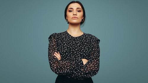 Empowered young woman standing alone in a studio
