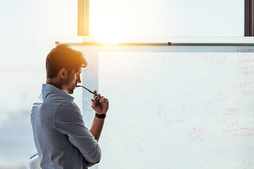 Entrepreneur putting his business ideas on whiteboard in boardroom.