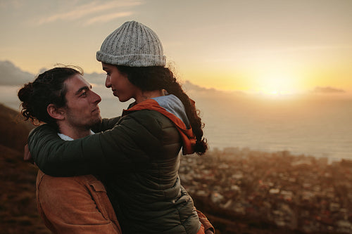 Affectionate couple on mountain at sunset