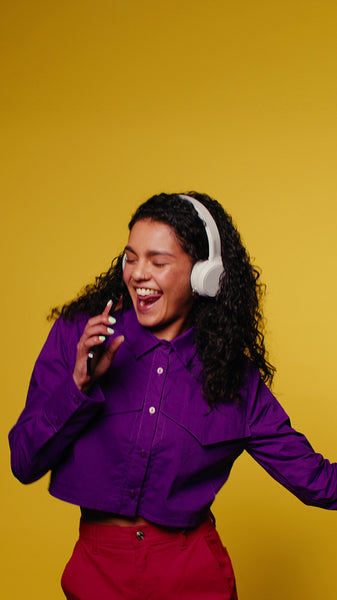 Young woman enjoys music, dancing and singing with headphones
