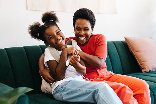 Happy mother and daughter having a playful morning on the couch