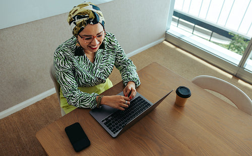 Professional woman radiating confidence and positivity in a private workplace setting