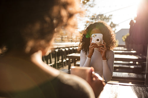 Woman clicking photo at a coffee shop