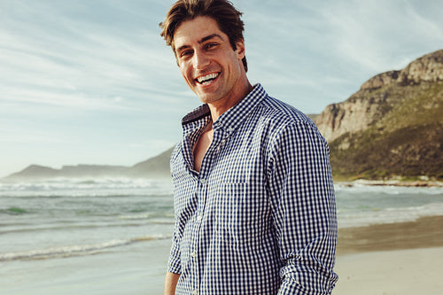 Handsome man smiling on the beach