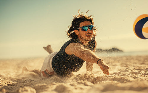 Dynamic beach volleyball game: Athlete soars mid air for an epic dive on sand court