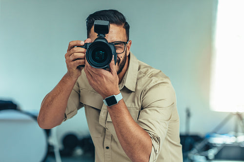 Portrait of a photographer taking photo standing in a studio