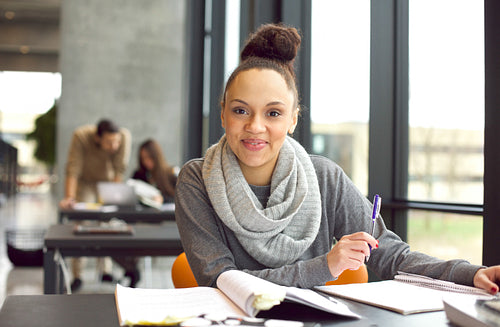Confident female student studying in library