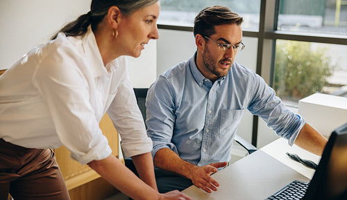 Office workers working together on laptop