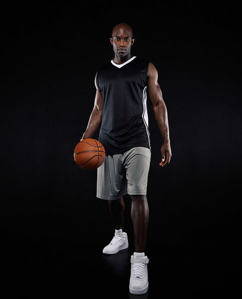 Confident young basketball player over black background