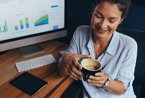Businesswoman having coffee break in office