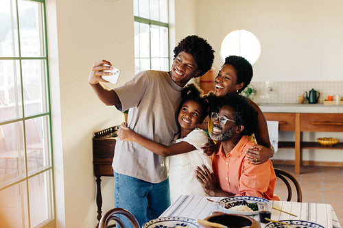 Happy Brazilian family taking a selfie together at mealtime