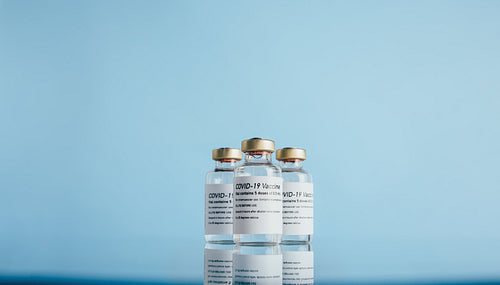 Covid-19 vaccine vials on reflective surface
