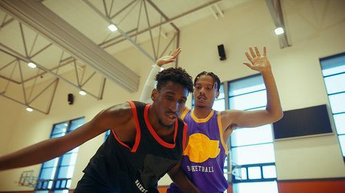 Young men playing basketball on court