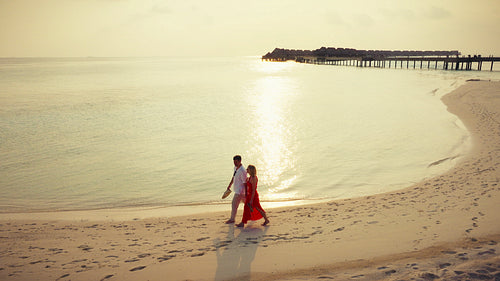 Mature couple enjoys a luxurious tropical beach sunset vacation by the ocean resort