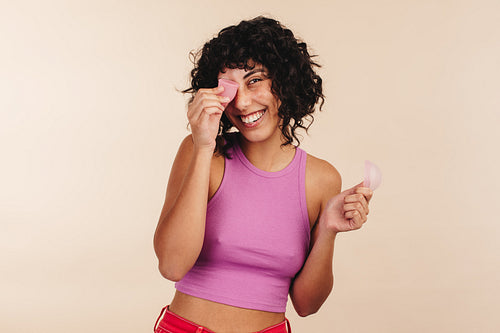 Cheerful woman holding a menstrual cup and a menstrual disc