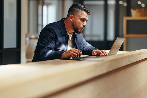 Web design professional working on a laptop in a coworking office