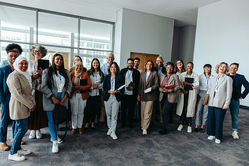 Diverse professional team posing happily at a seminar event indoors