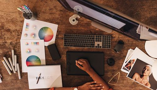 Top view of a graphic designer working at her desk