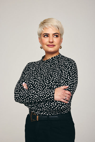Blonde woman standing alone in a studio