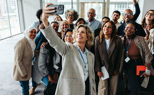 Diverse team taking a group selfie during seminar or workshop