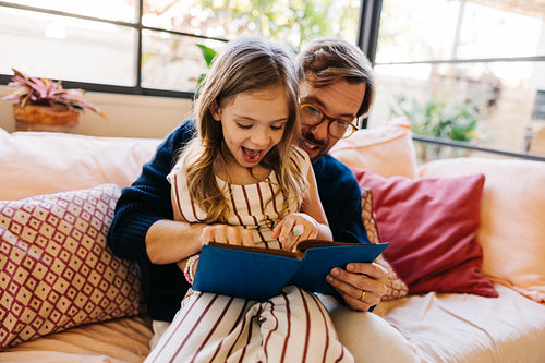 Family reads together on cozy couch
