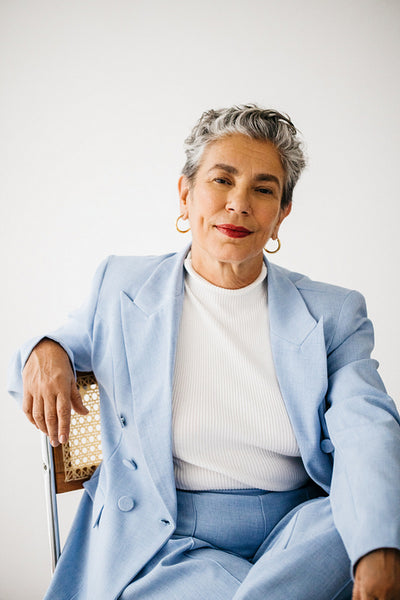 Senior confidence and empowerment: Mature business woman sitting on a chair in a professional suit